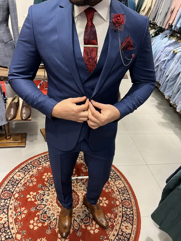 Costume bleu élégant avec cravate rouge et rose boutonnière