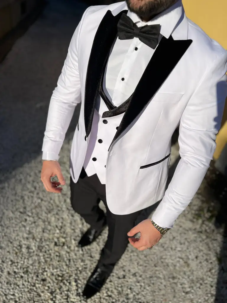 Homme en smoking blanc avec nœud papillon noir