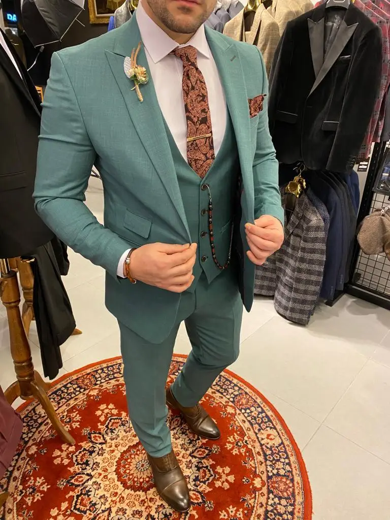 Homme portant un costume élégant vert menthe avec cravate.