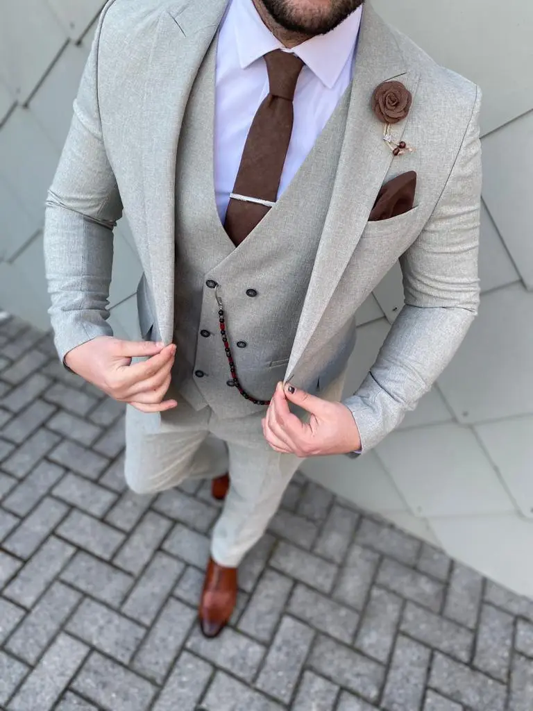 Homme en costume gris clair avec cravate marron