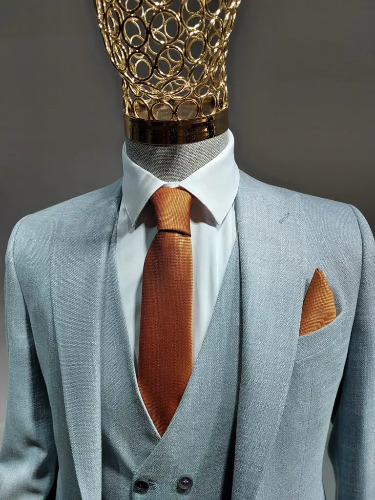 Costume trois pièces gris clair avec cravate orange