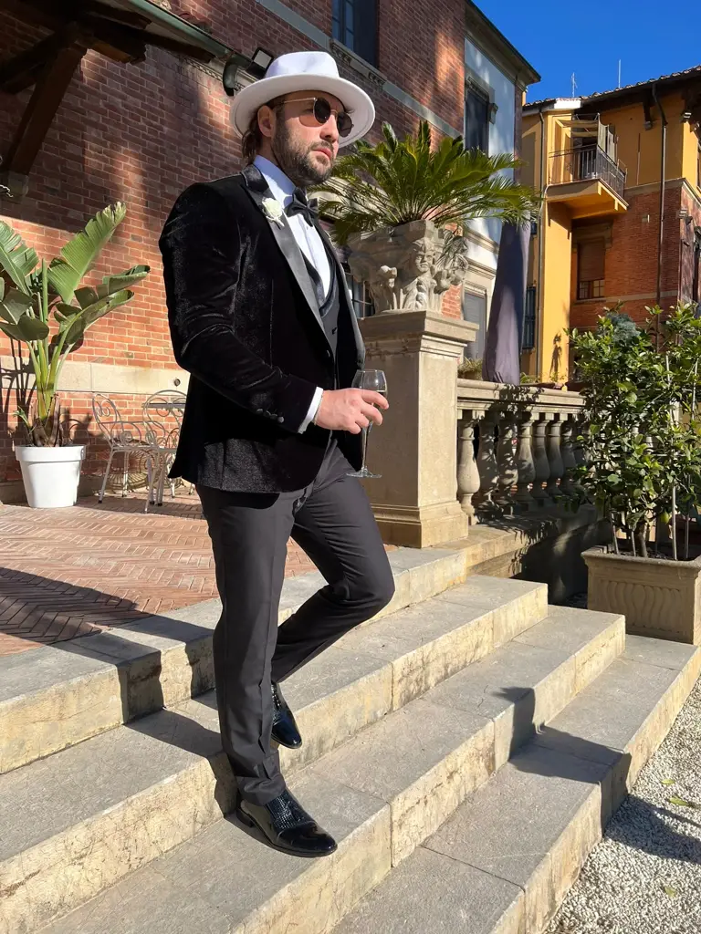 Homme élégant en costume noir avec chapeau blanc